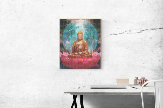 Diamond painting van een mediterende Boeddha op een roze lotusbloem met een blauwe aura op de achtergrond, opgehangen boven een minimalistisch bureau tegen een grijze muur.