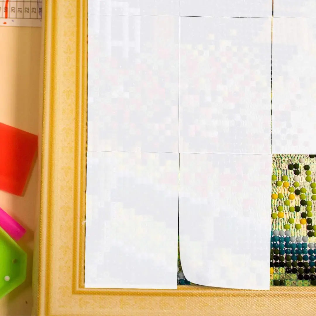 Meerdere witte afdekvellen bedekken een diamond painting canvas om secties af te schermen tijdens het plakken.
