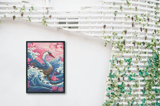 Diamond painting van een zwaan met roze en blauwe golfpatronen, ingelijst aan een witte muur met hangende groene planten.