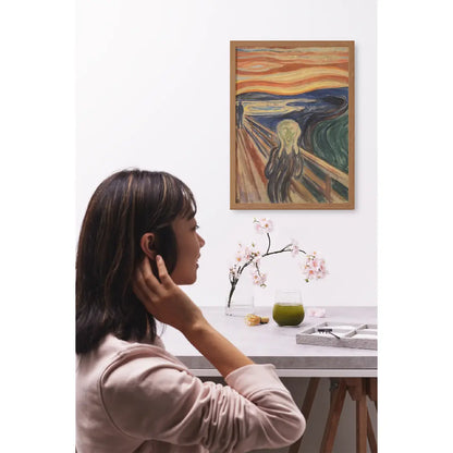 Diamond painting van De Schreeuw van Edvard Munch, weergegeven in een moderne ruimte met een vrouw die naar het schilderij kijkt.