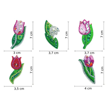 Vijf diamond painting sleutelhangers in de vorm van kleurrijke tulpen, elk met een ander kleurenschema en versierd met glinsterende details, afmetingen variërend tussen 3 en 4 cm breed en 7 cm hoog.