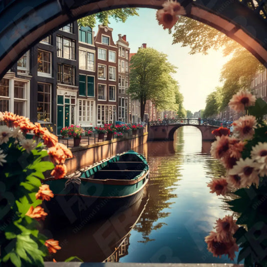 Diamond painting van Amsterdamse grachten, met een bootje en bloemen aan de waterkant onder een brug.