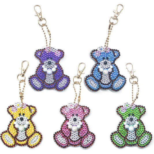 Verzameling van diamond painting sleutelhangers in de vorm van beren in verschillende kleuren.