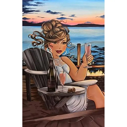 Dikke Dames diamond painting van een vrouw in een witte jurk die een glas champagne heft bij zonsondergang, met een fles op een tafel naast haar.