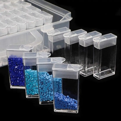 Doorzichtige opbergdoos voor diamond painting met diverse blauwtinten steentjes in losse doosjes, geplaatst op een zwarte achtergrond.