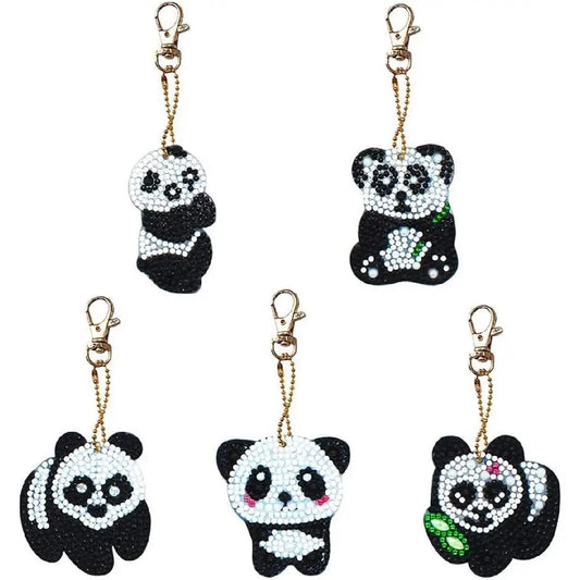 Collectie van vijf diamond painting panda sleutelhangers, elk in een unieke pose en versierd met kleurrijke accenten.