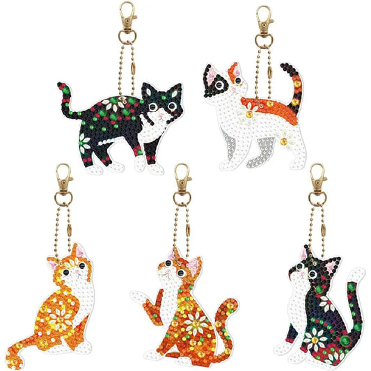 Collectie van verschillende speelse kattensleutelhangers in diamond painting stijl, ideaal voor decoratie van persoonlijke items.
